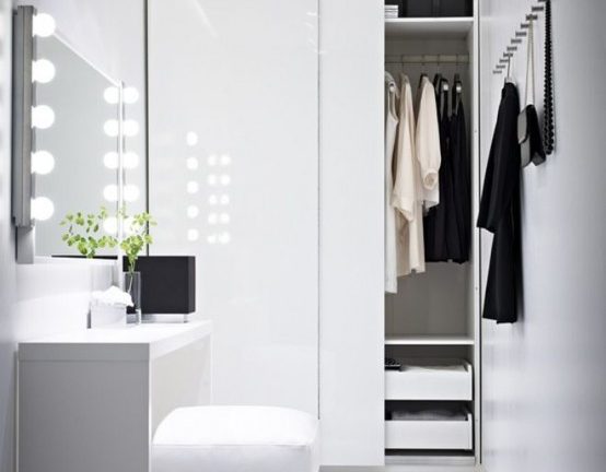 witte minimalistische kledingkast met hoogglans deuren en klein bureau voor spiegel